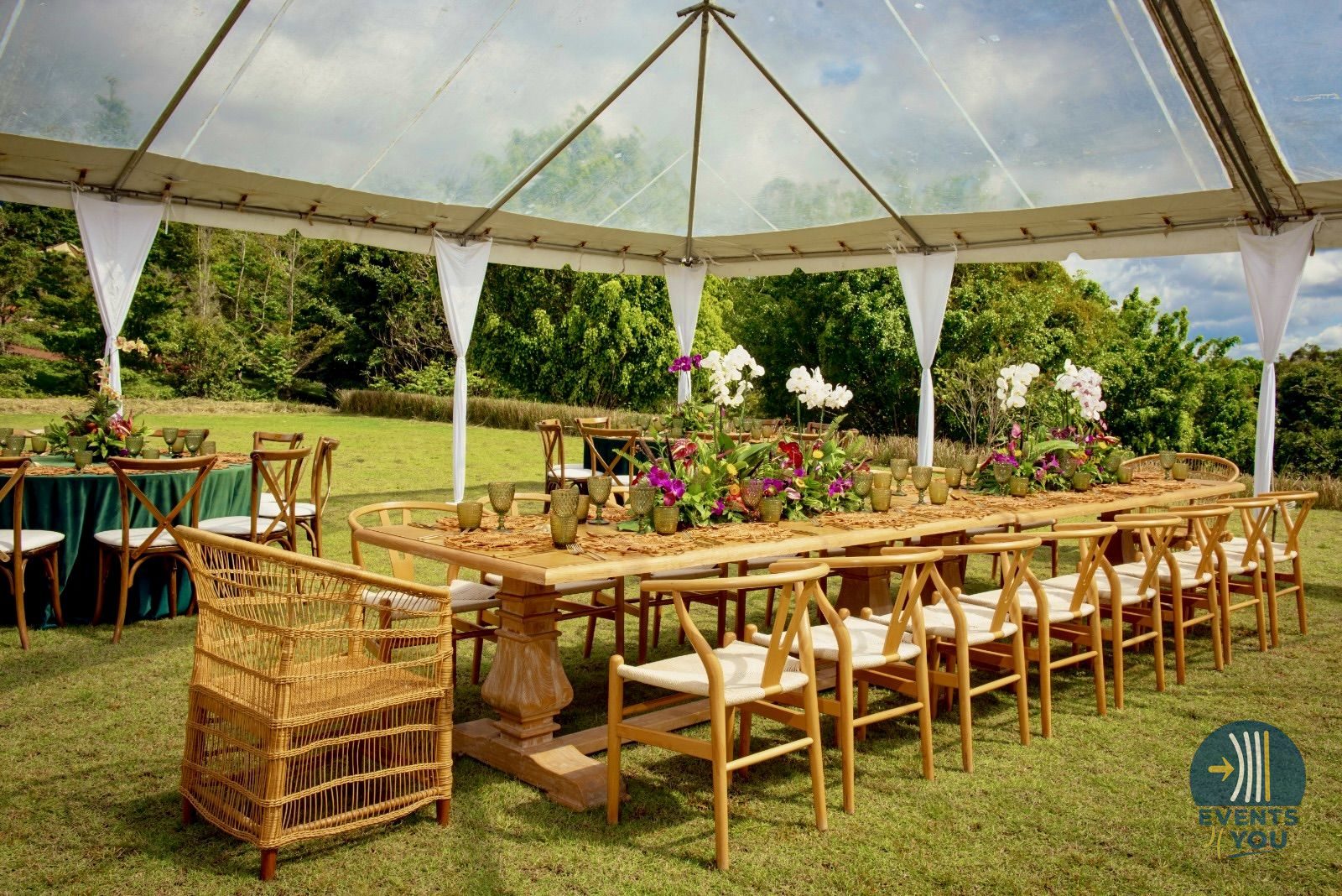 Mesa larga decorada bajo carpa al aire libre